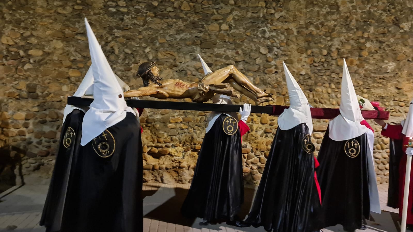 Vía Crucis Procesional: silencio y oración entrecosidos a la muralla de León. El Miércoles Santo se cierra con el Vía Crucis Procesional alumbrado por los hermanos de la Cofradía de las Siete Palabras de Jesús en la Cruz fieles al paso del yacente santísimo Cristo de la Agonía. 