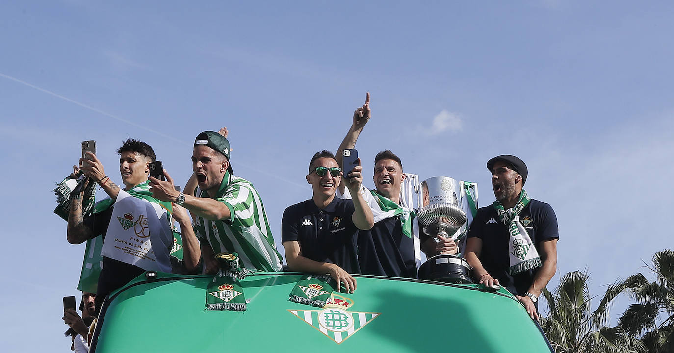 Jugadores del Betis saludan desde el autocar durante su recorrido con destino al ayuntamiento de Sevilla, para celebrar su título de Copa del Rey. 