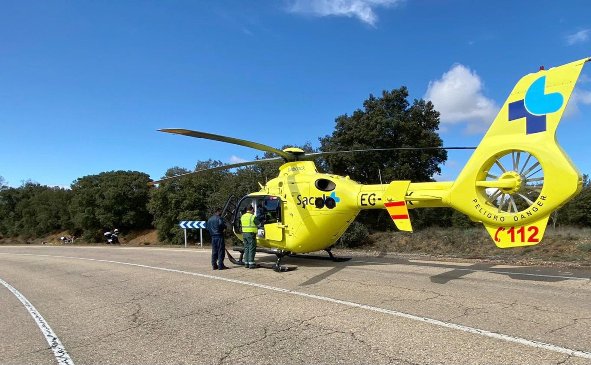 Imagen del lugar del accidente ocurrido este miércoles, con el helicóptero medicalizado del Sacyl que atendió al motorista en primer término; al fondo, los restos de la moto accidentada. 