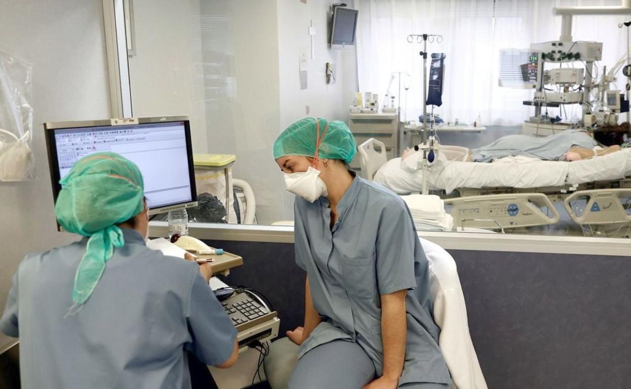 Dos enfermeras en una unidad de críticos con pacientes covid. 