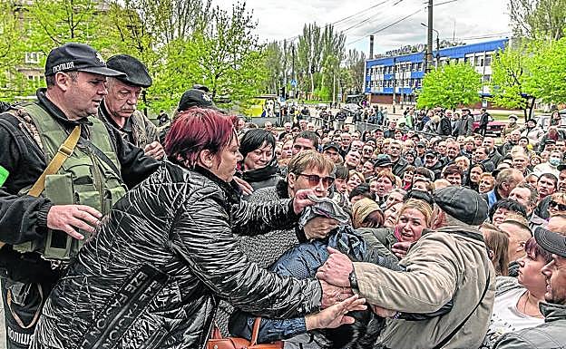 Cientos de familias se agolpan ante un puesto de control de Zaporiyia para recibir ayuda humanitaria.