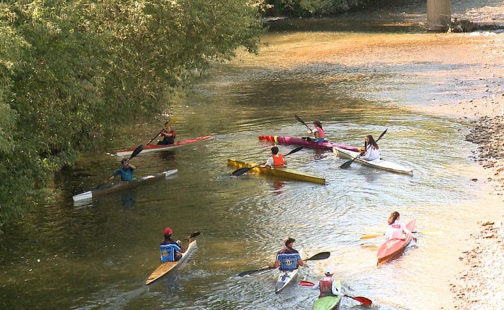 Un grupo de deportistas practica piragüismo en las aguas del Bernesga a su paso por León capital. A ellos les toca sufrir la acumulación de piedra y lodo. 