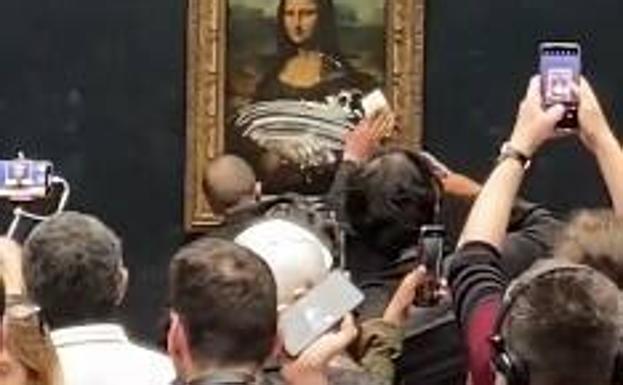 Momento captado en una grabación del momento en el que el individuo lanza el pastel contra 'La Gioconda'.