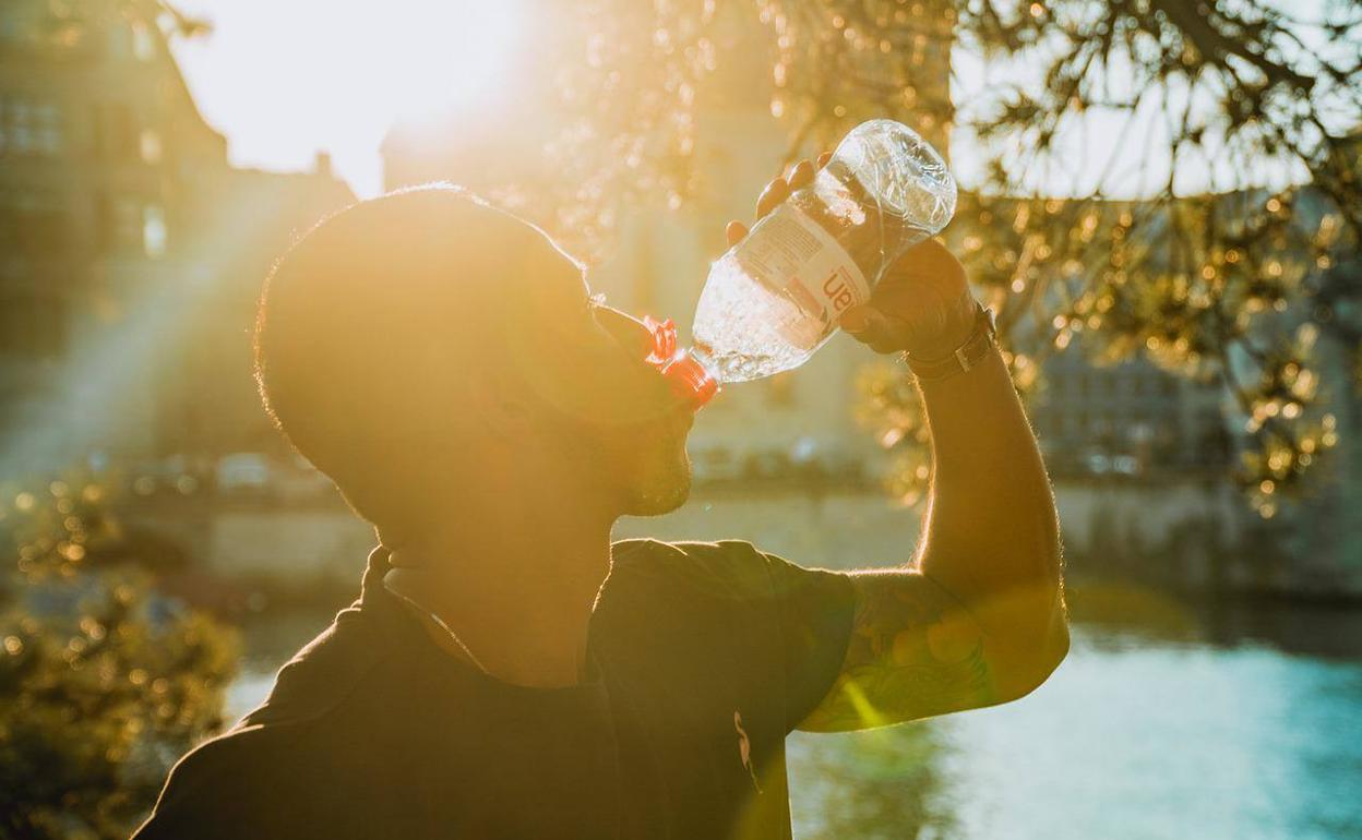 Un joven se refresca ante una calurosa y soleada jornada. 