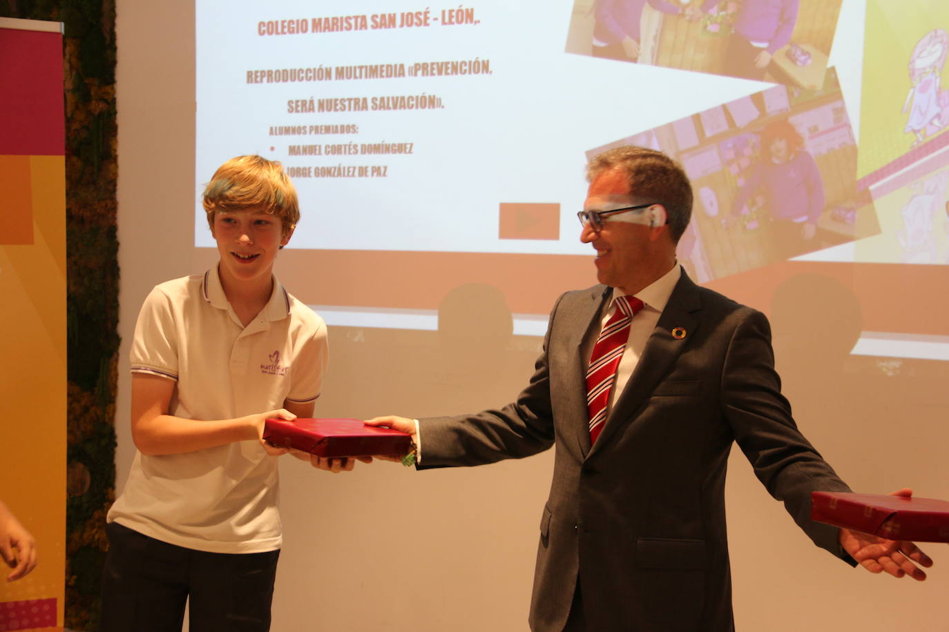 El consejero de Industria, Comercio y Empleo, Mariano Veganzones, entrega a los alumnos de primaria Manuel Cortés y Jorge González de Paz de este colegio leonés el galardón por su vídeo en el que repasan la importancia de prevenir en el colegio yen el trabajo para mejorar la seguridad.