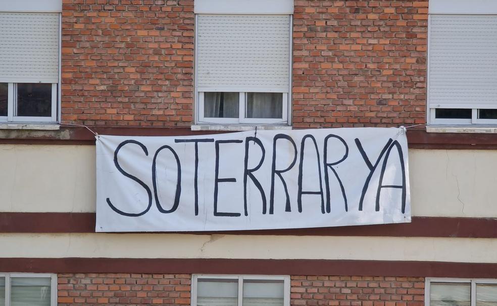 Imagen de una enorme pancarta en una vivienda 'enterrada' por el ferrocarril. 