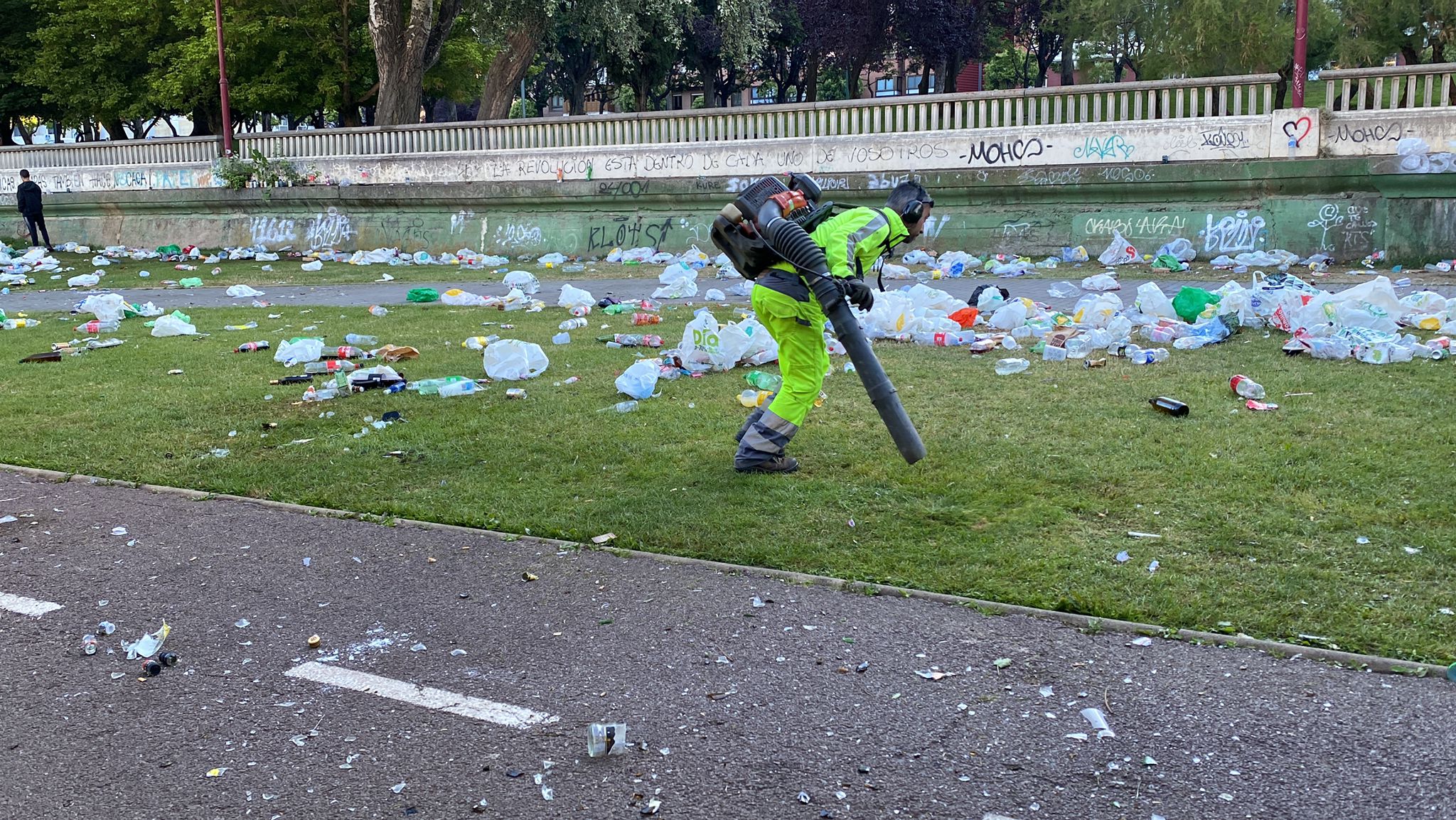 San Pedro se cita con el botellón a orillas del Bernesga. Las brigadas del Servicio de Jardines del Ayuntamiento de León recoge kilos de basura que los más jóvenes dejaron durante la pasada noche en una nueva fiesta en la ribera del río.