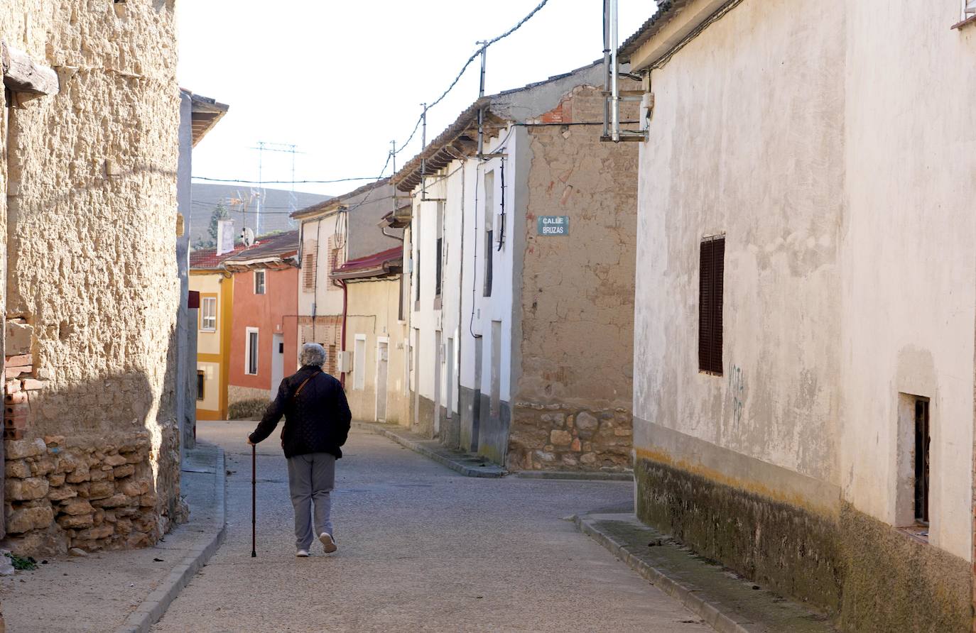 Una mujer camina por un pueblo de Castilla y León.