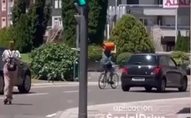 Un ciclista circula por León con una bombona de butano al hombro..