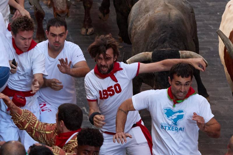 Los mozos corren ante los toros de la ganadería de José Escolar durante el tercer del encierro de San Fermín.