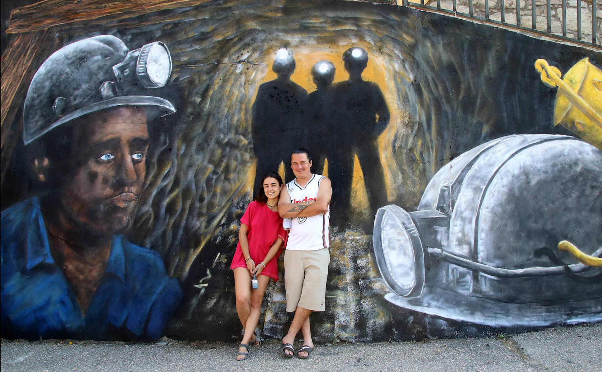 Esecé y Raquel Moledo posan junto al mural realizado en Santa Lucñia de Gordón.