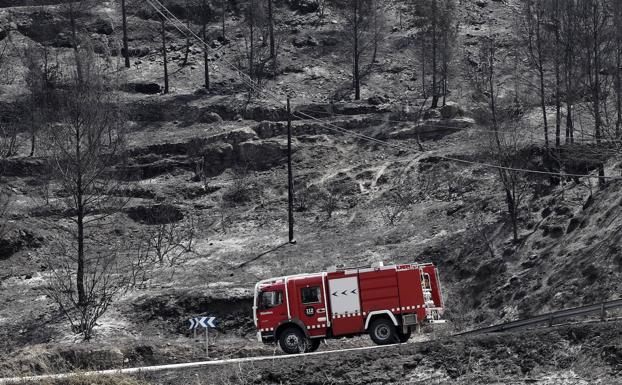 Un camión de bomberos atraviesa este lunes parte de las 1.600 hectáreas calcinadas en el incendio aún activo de Pont de Vilomara (Barcelona). 