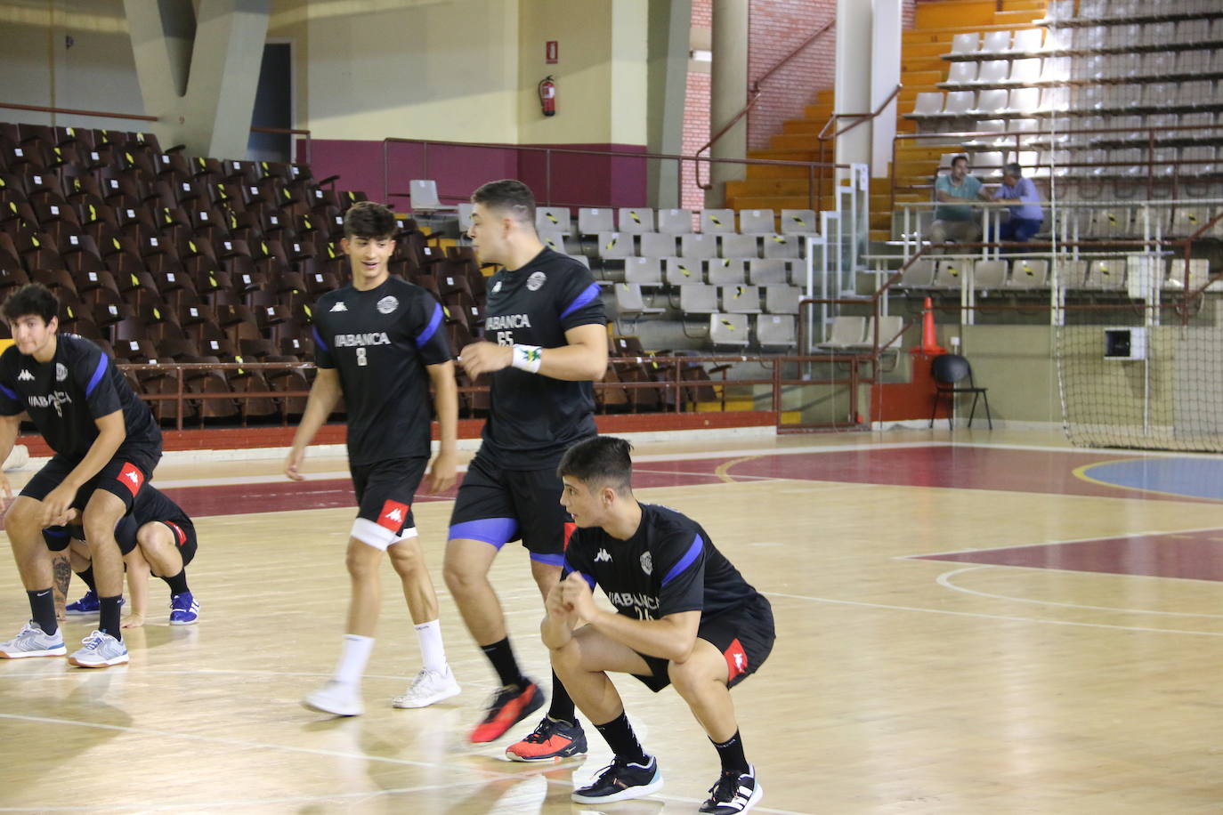 La plantilla del Ademar realiza flexiones en medio de la cancha del Palacio de los Deportes. 