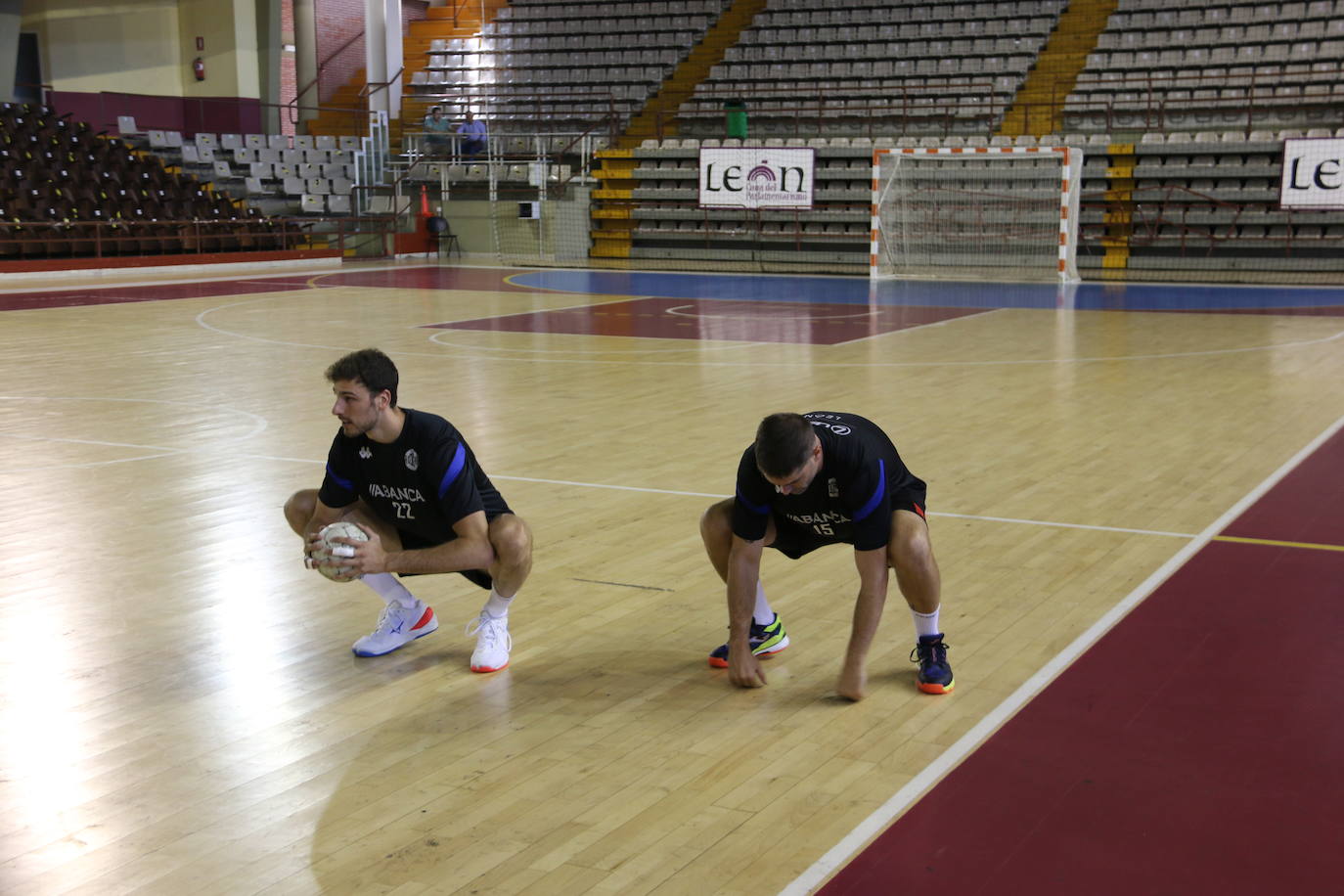 La plantilla del Ademar realiza flexiones en medio de la cancha del Palacio de los Deportes. 