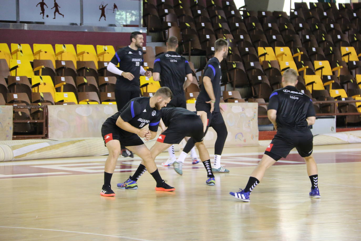 La plantilla del Ademar realiza flexiones en medio de la cancha del Palacio de los Deportes. 