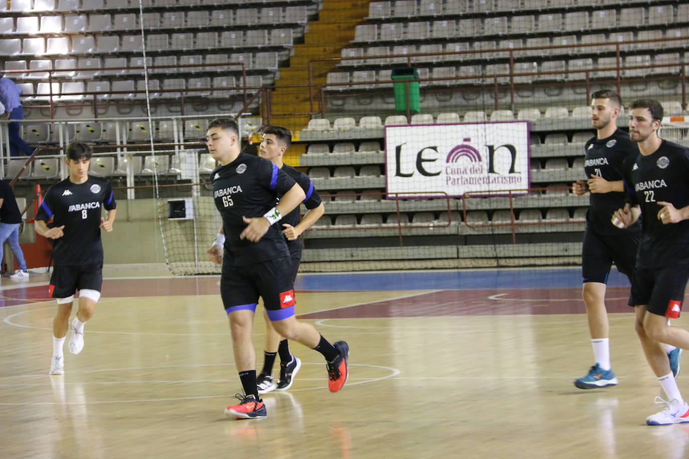 La plantilla del Ademar realiza flexiones en medio de la cancha del Palacio de los Deportes. 