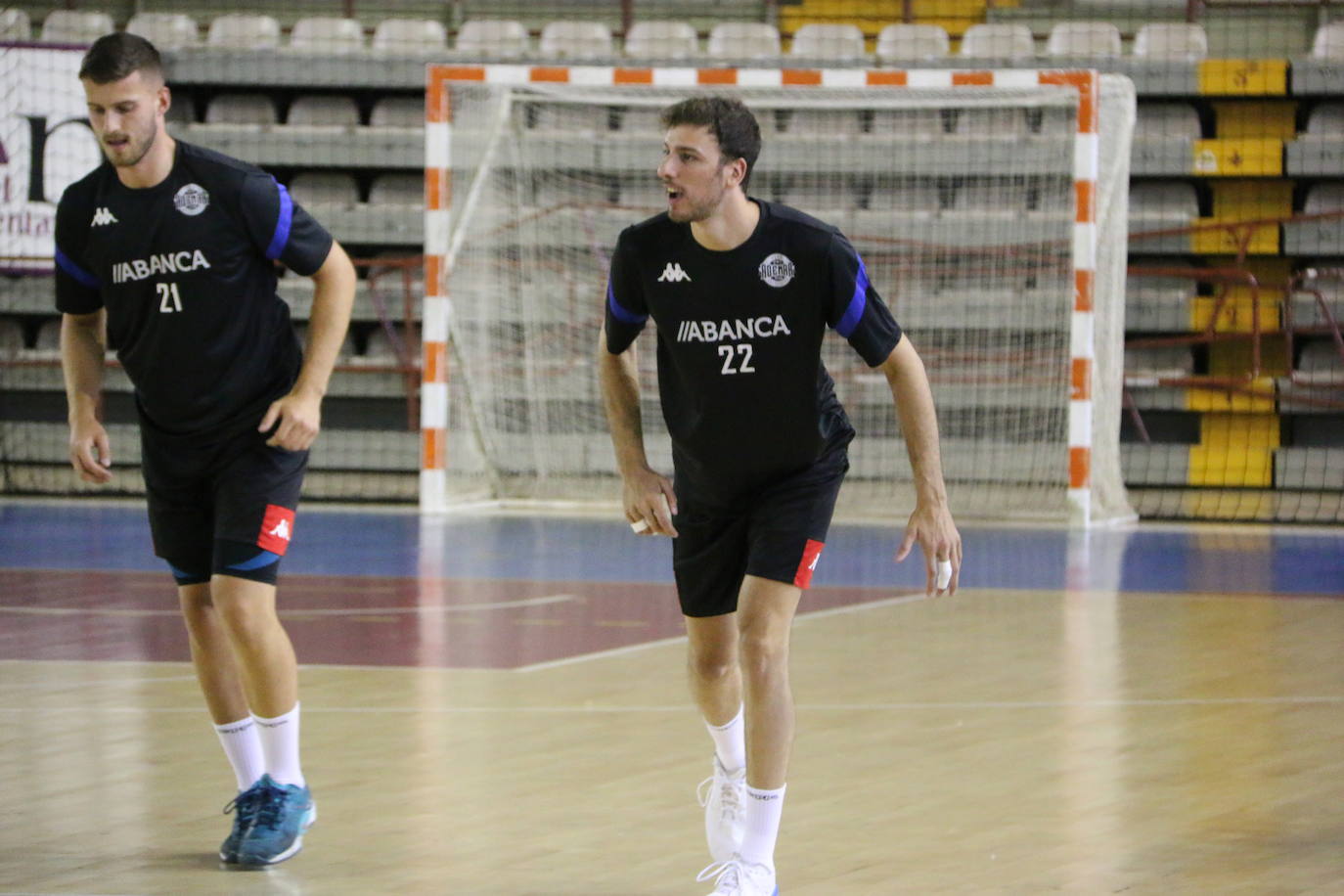 La plantilla del Ademar realiza flexiones en medio de la cancha del Palacio de los Deportes. 