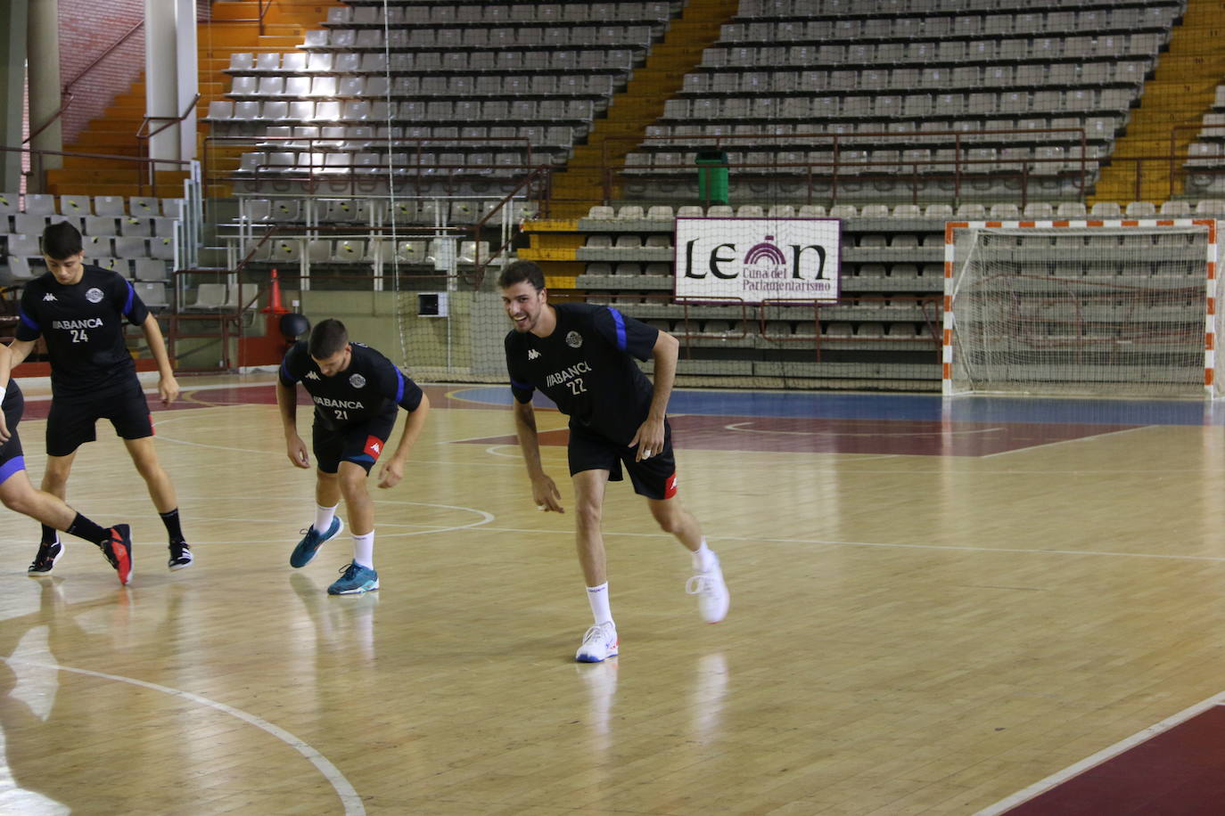 La plantilla del Ademar realiza flexiones en medio de la cancha del Palacio de los Deportes. 