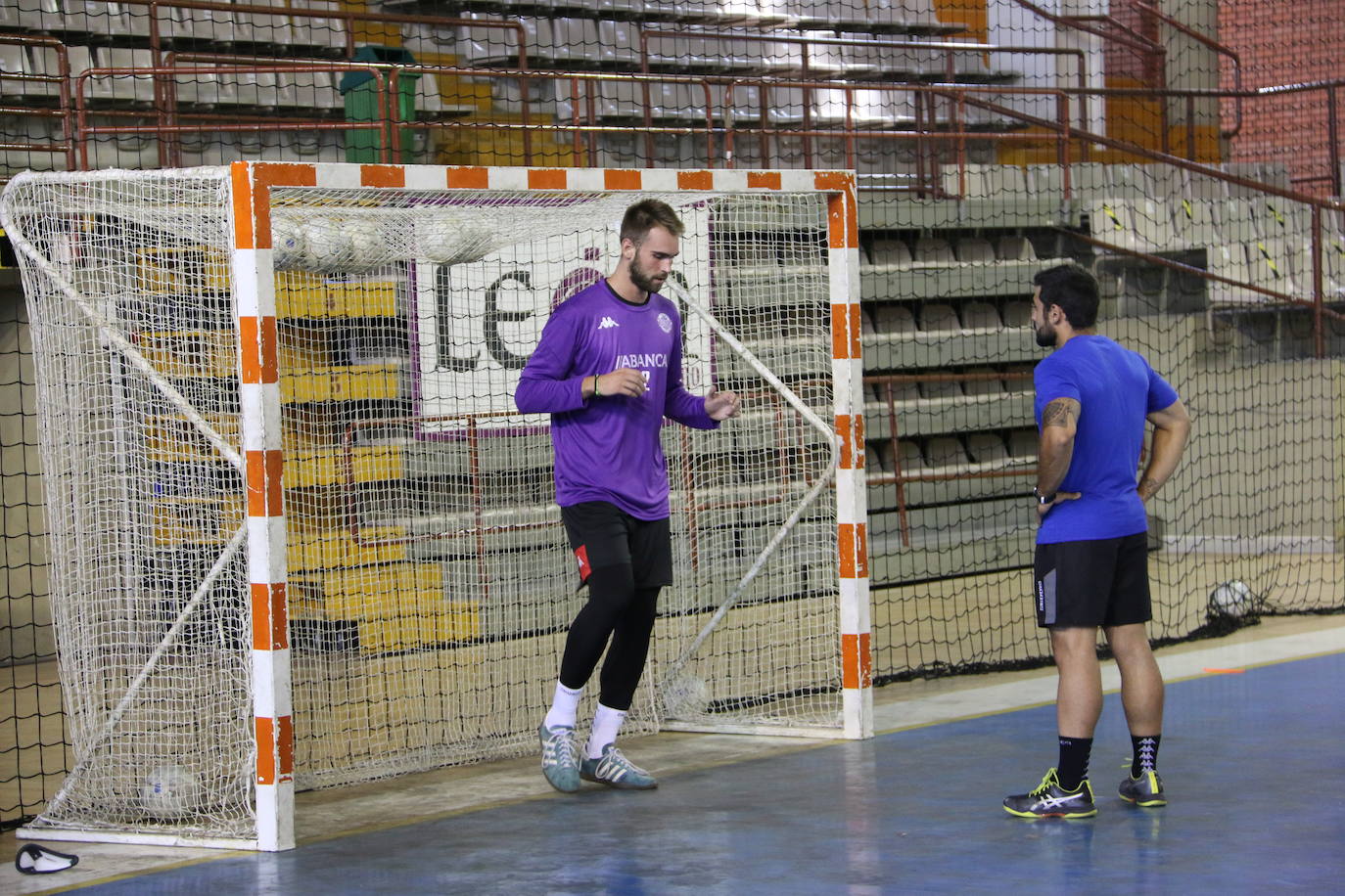 La plantilla del Ademar realiza flexiones en medio de la cancha del Palacio de los Deportes. 