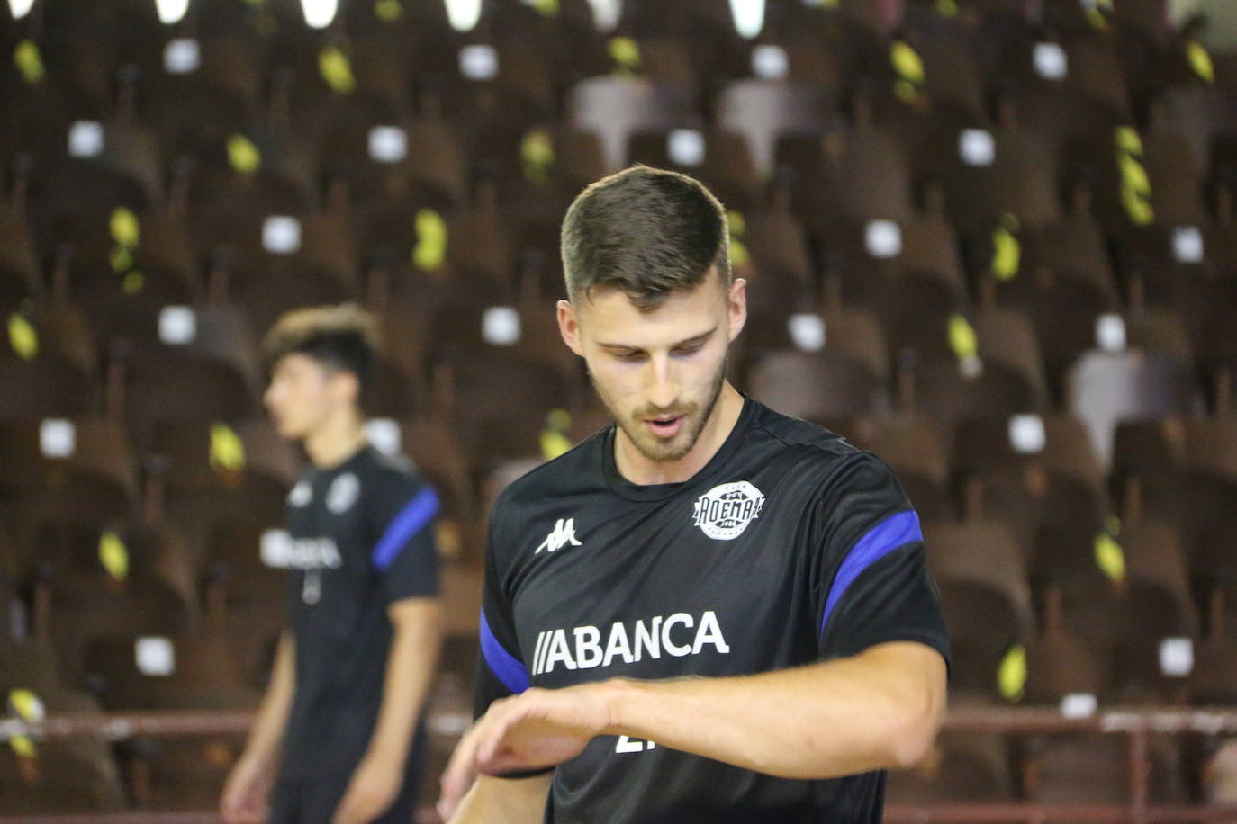 La plantilla del Ademar realiza flexiones en medio de la cancha del Palacio de los Deportes. 