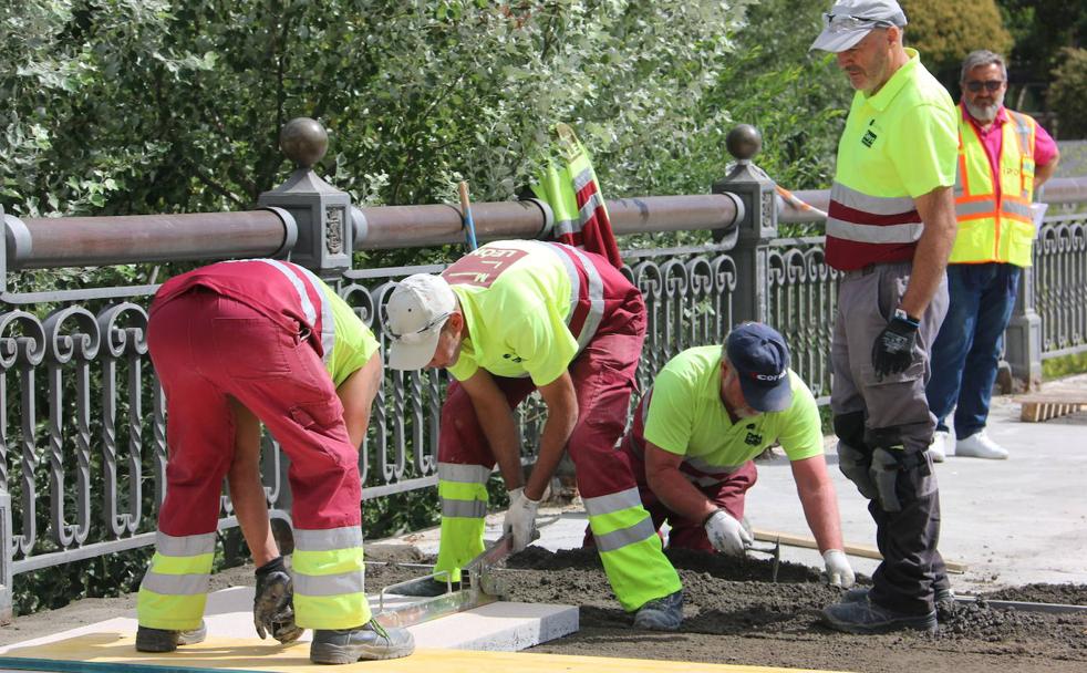 Los operarios de la UTE Mantenimiento de León trabajan en la superficie del puente para mejorarlo.