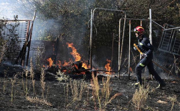 Un bombero corre para apagar un fuego en el campo.