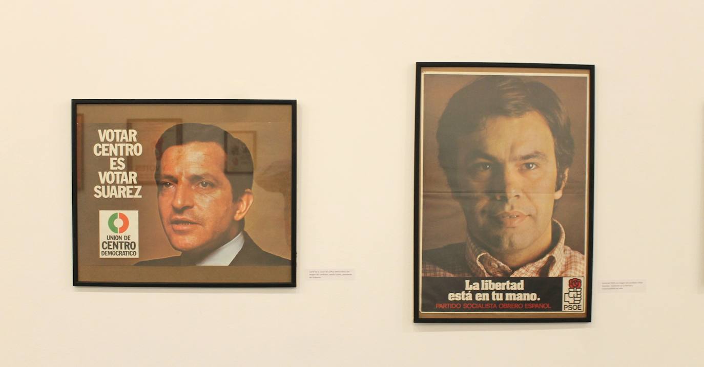 Miguel Gutiérrez psoa con algunos de los carteles que se pueden observar en la exposición.