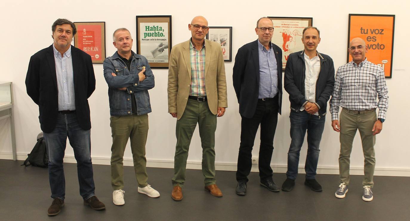 Miguel Gutiérrez psoa con algunos de los carteles que se pueden observar en la exposición.