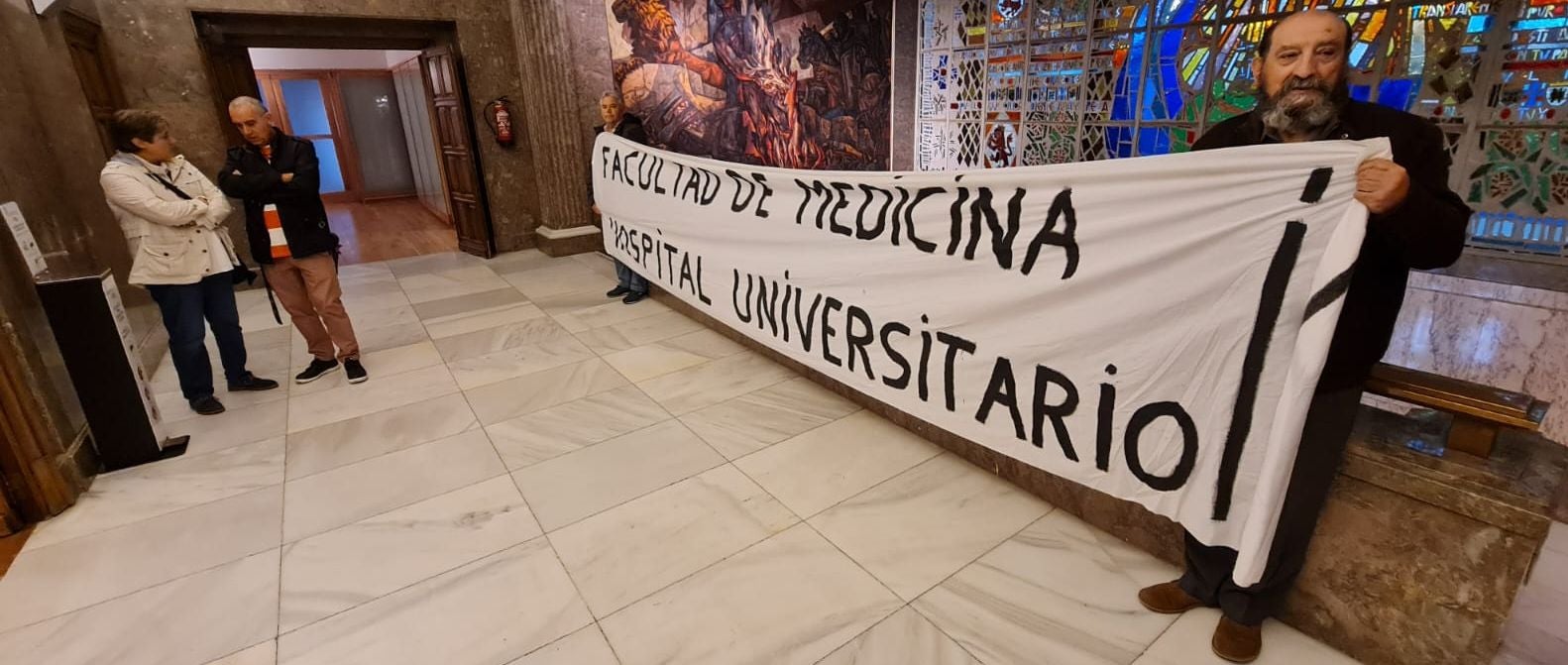 Los leonesistas Félix Pérez Echevarría 'Cheva' y Paco León llevan a las puetas del pleno municipal una reivindicativa pancarta por la Facultad de Medicina para León. «Es un derecho de León y los leoneses y llevamos dos décadas exigiendo que se instale en León», aseguran.