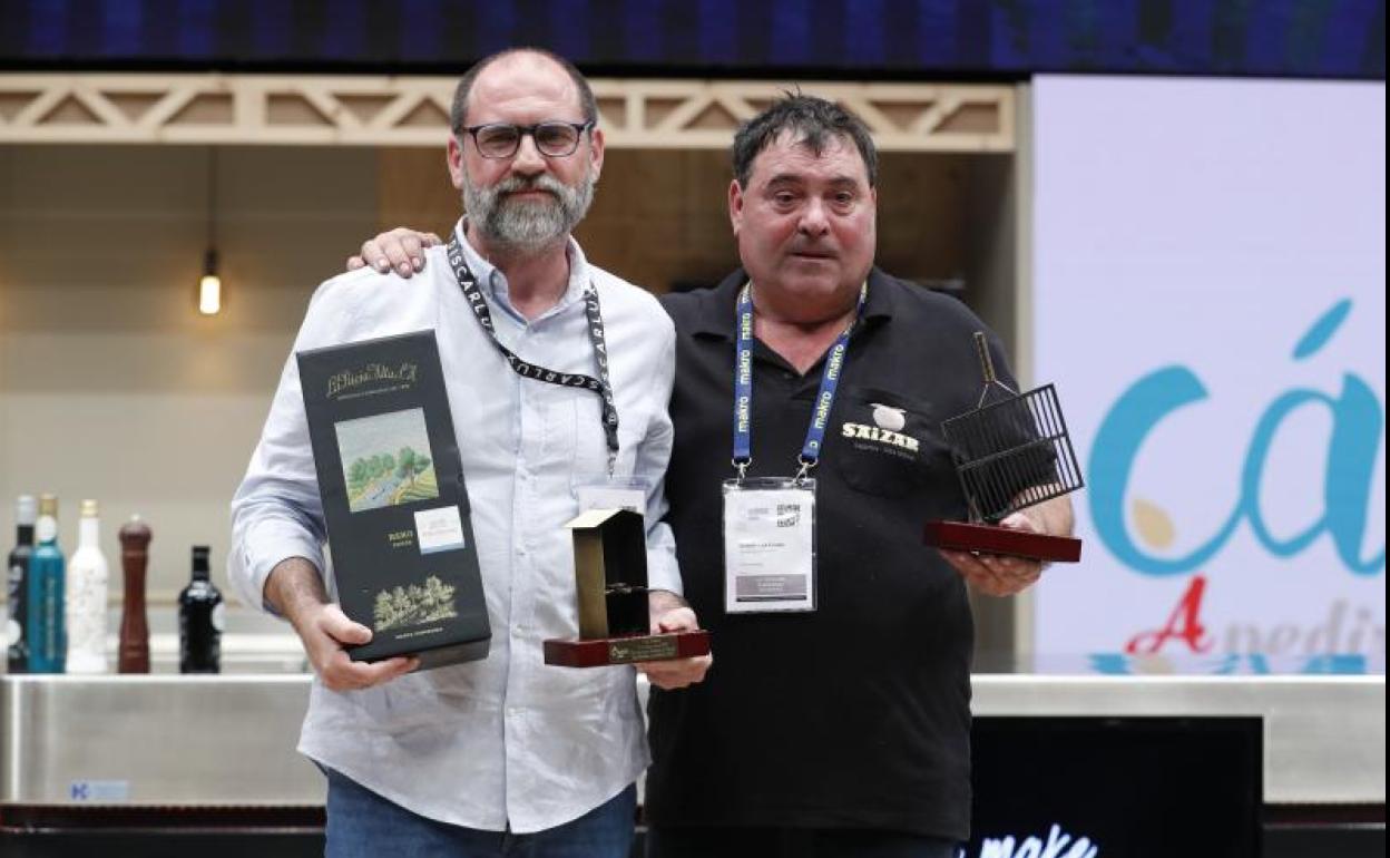 El parrillero de Saizar Sagardotegia, Ramón Lertxundi (d), y el responsable de Discarlux, Carlos González (i), posan con los trofeos de vencedores del XIII Concurso Nacional de Parrilla.