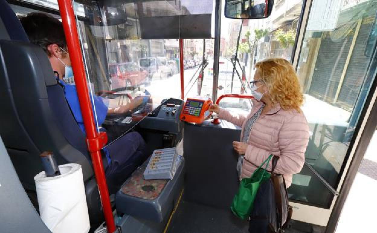 Una usuaria del autobús paga el acceso con la mascarilla, que sigue siendo obligatoria. 