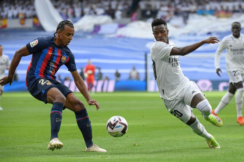 Vinicius pugna por un balón con Koundé.