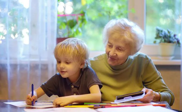 Una abuela ayuda a su nieto a hacer los deberes./Maria Sbytova