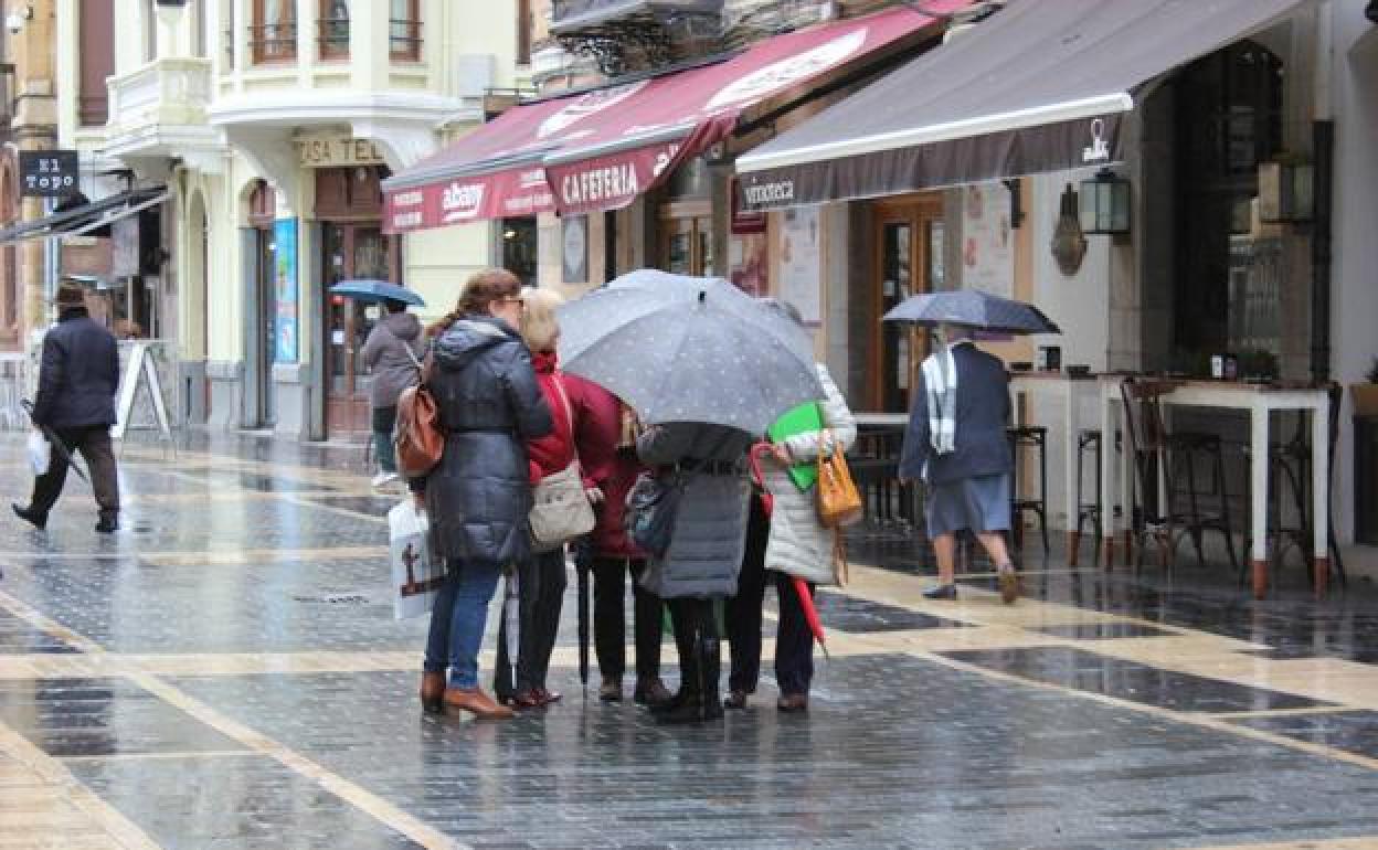 Un grupo de ciudadanos conversa en la calle Ancha de León.