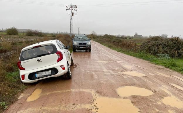 Imagen de un vehículo fuera del camino que da acceso a Agrovet tras deslizarse sobre el barro. 