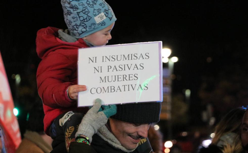 Un niño sujeta un cartel a hombros de su padre en la manifestación de este viernes en León capital.