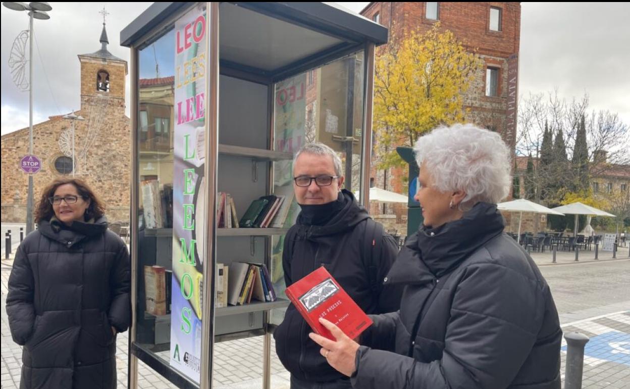 La bibliotecaria de Astorga junto con el técnico de Cultura y la concejal del área frente a la primera cabina-biblioteca. 