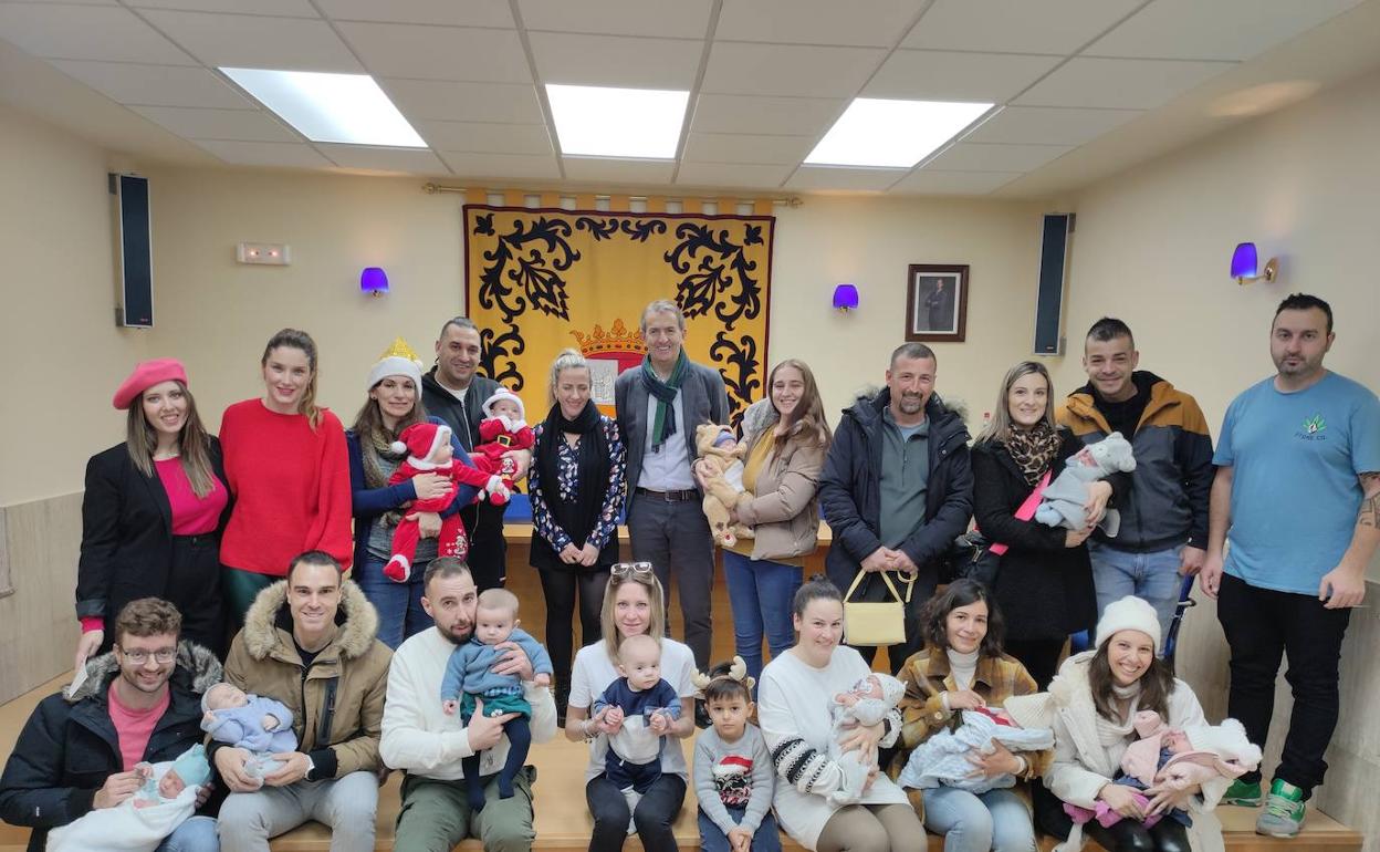 Los bebés nacidos en La Robla y sus padres posan en el Salón de Plenos del Ayuntamiento de la localidad. 