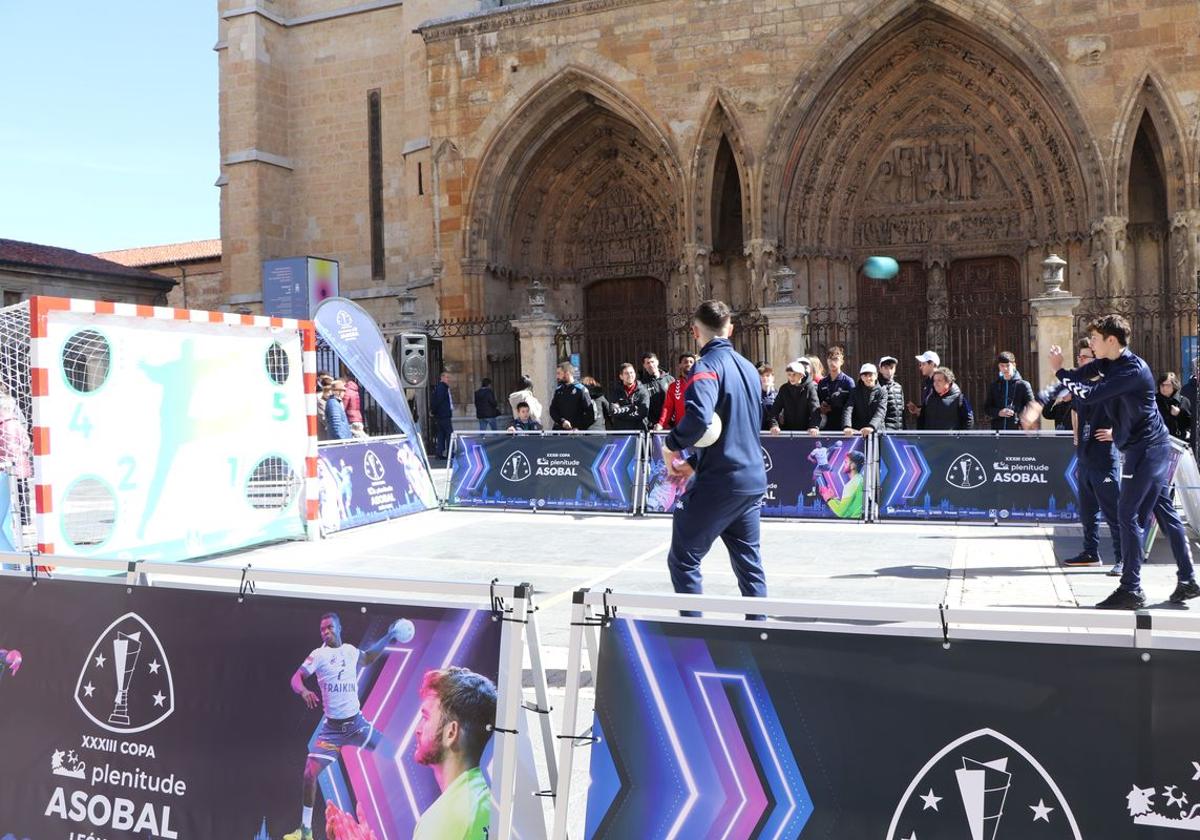 Los aficionados al balonmano lanzando balones a una portería situada a los pies de la Catedral.