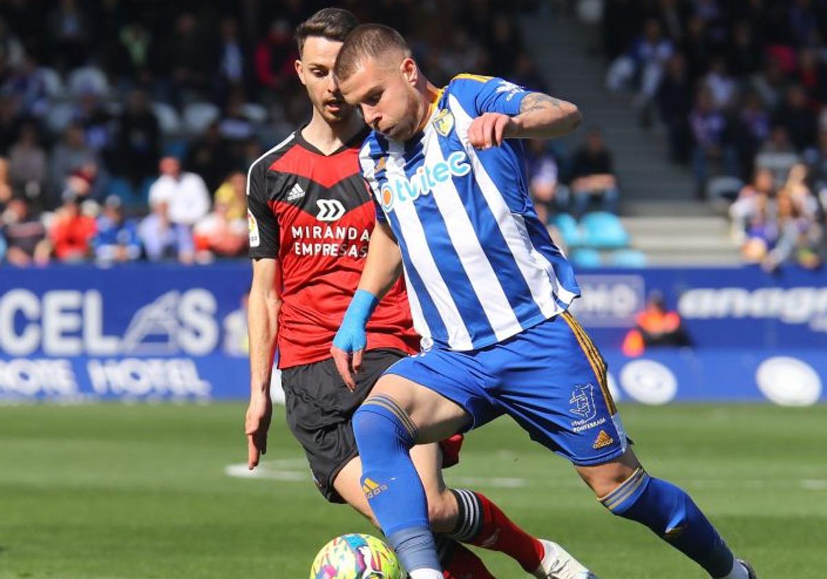 Amo porfía un balón con el delantero del Mirandés, Raúl García.