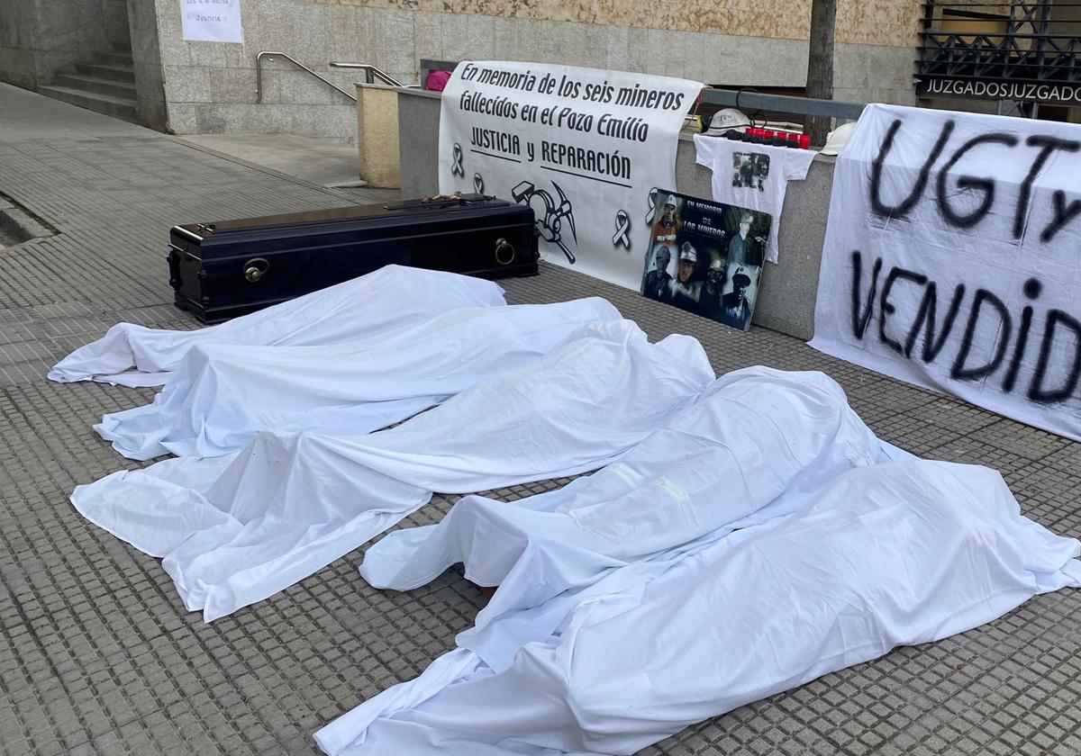 Un ataúd y cinco cuerpos cubiertos con sábanas a las puertas de los Juzgados de León.