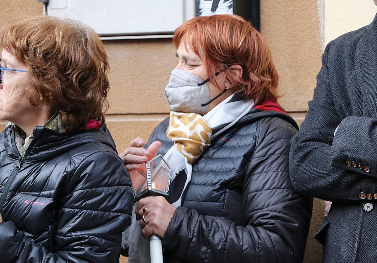 Una mujer porta una vela durante la procesión.