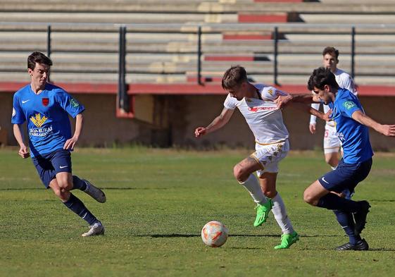 Un jugador del Santa Marta agarra a otro del Júpiter Leonés para evitar su avance.