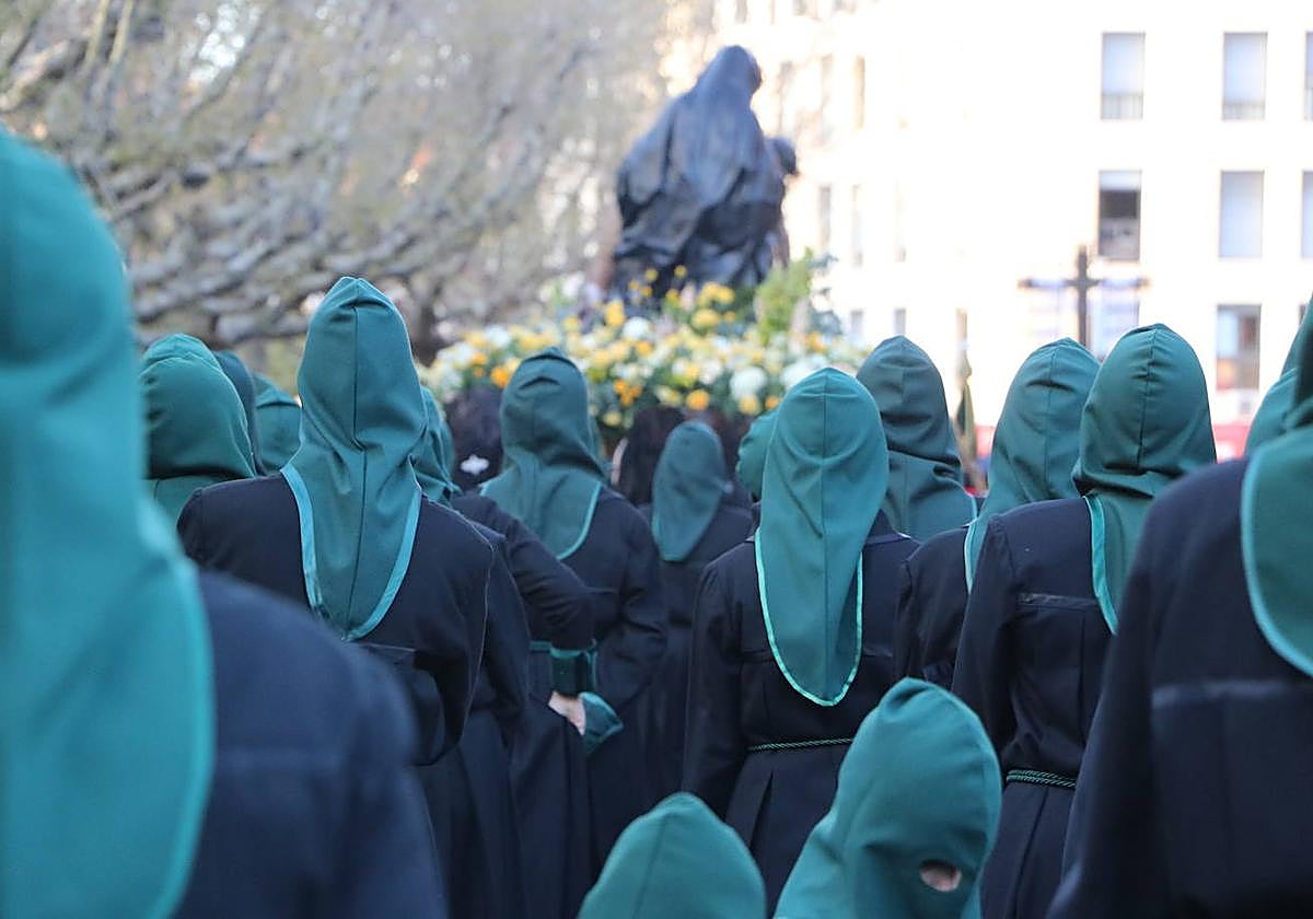 Miles de mujeres con capillo verde participan en la procesión de este Jueves Santo.