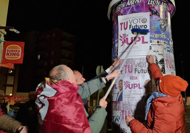 Eduardo López Sendino, arropados por leonesistas, durante la pegada de carteles de este viernes.