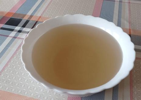 Imagen secundaria 1 - En la imagen de arriba y el centro, estado del agua en Pedrún el pasado domingo 4 de junio, según el Ayuntamiento; en la imagen de abajo, una vecina de Pedrún de Torío sostiene un vaso de agua del grifo.