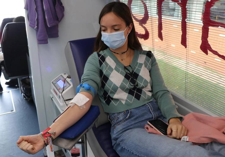 Una joven estudiante de la Universidad de León dona sangre en el bus estacionado frente a la Facultad de Educación.