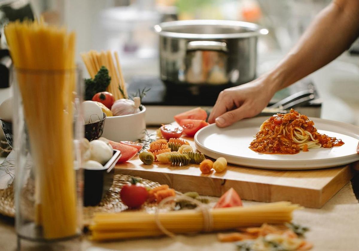 Imagen de una persona cocinado pasta en una cocina.