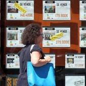 Una mujer frente a una empresa inmobiliaria.