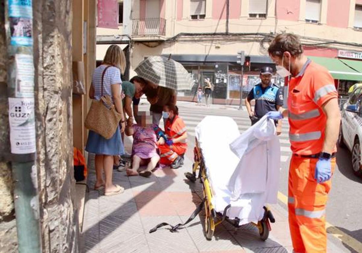 Sanitarios atienden a una mujer por un golpe de calor en una calle de León en julio de 2022.